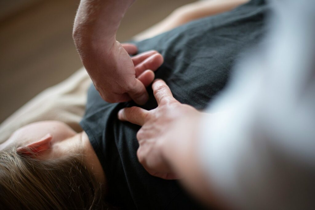 a woman laying on top of a bed holding a mans hand